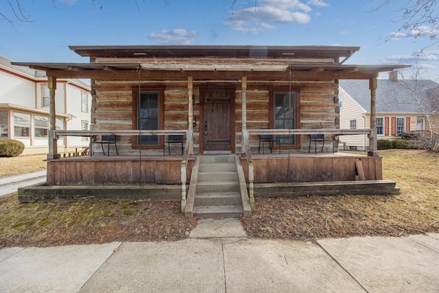 view of front of home with a porch and log siding