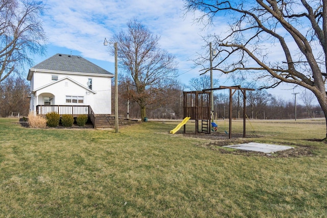 view of yard featuring a wooden deck and a playground