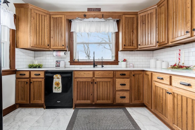 kitchen with black dishwasher, sink, and decorative backsplash