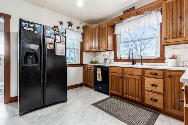 kitchen featuring tasteful backsplash, sink, and black appliances