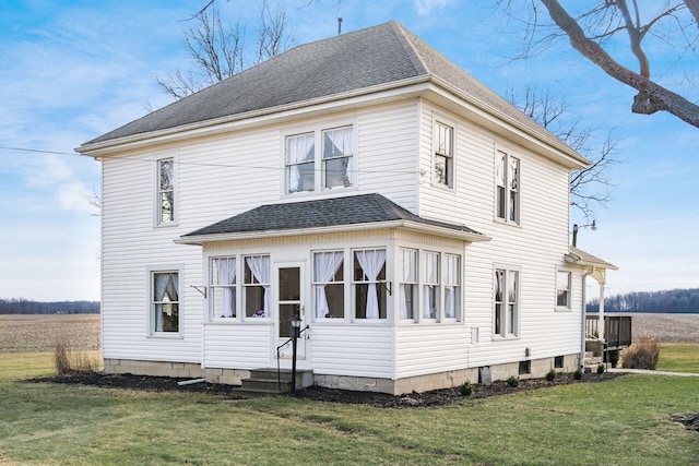 rear view of house featuring a yard