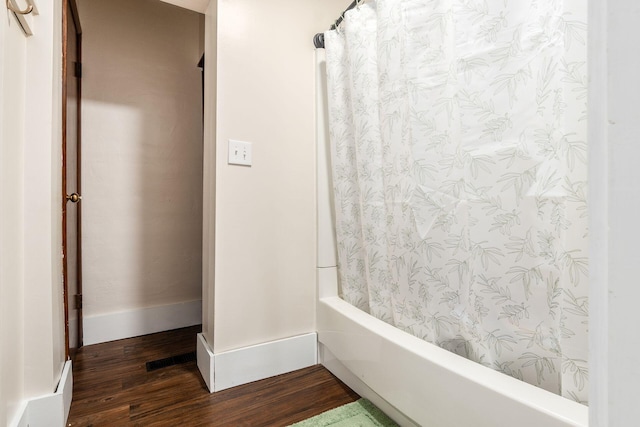 bathroom with shower / tub combo with curtain and hardwood / wood-style flooring