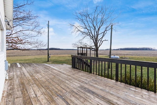 wooden deck featuring a lawn and a rural view