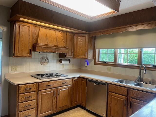 450 Yale Ave, Lima, OH 45804 - kitchen with brown cabinets, a sink, stainless steel appliances, backsplash, and custom exhaust hood