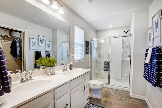 bathroom with a shower with door, vanity, hardwood / wood-style flooring, and toilet