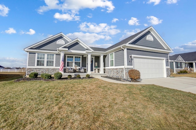 craftsman-style home with a garage, a front lawn, and a porch