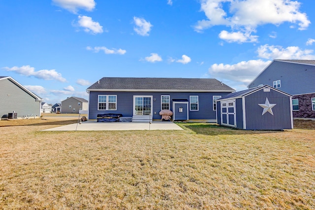 rear view of house with a yard, a patio, and a storage unit