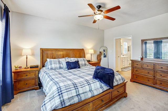 bedroom featuring light carpet, connected bathroom, and ceiling fan