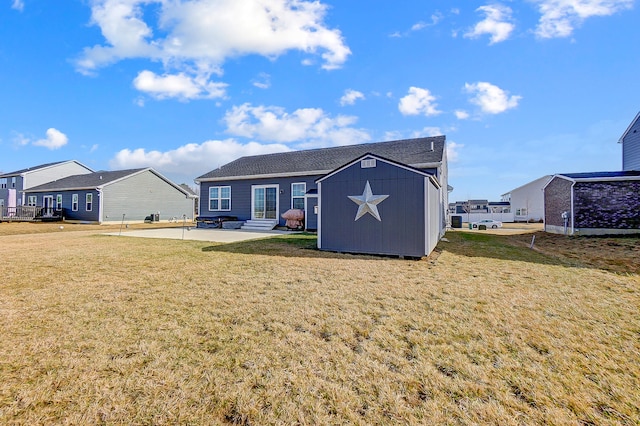 back of property featuring a storage shed, a yard, and a patio