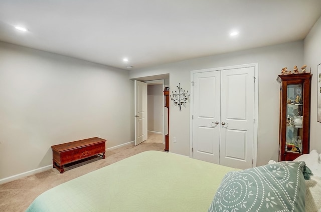 bedroom featuring light colored carpet and a closet