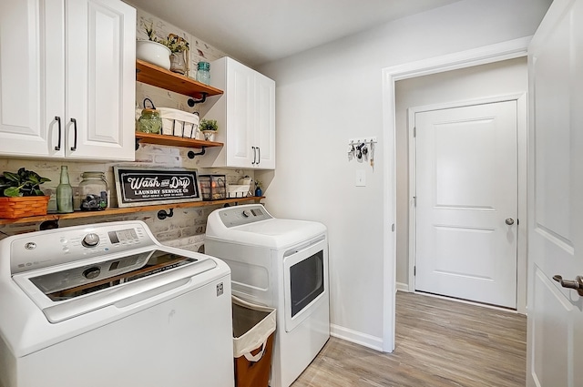 laundry area featuring cabinets, washing machine and dryer, and light wood-type flooring