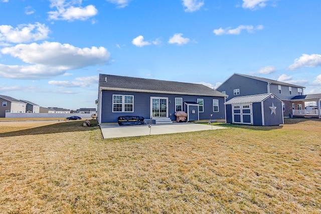 back of property with a storage shed, a lawn, and a patio