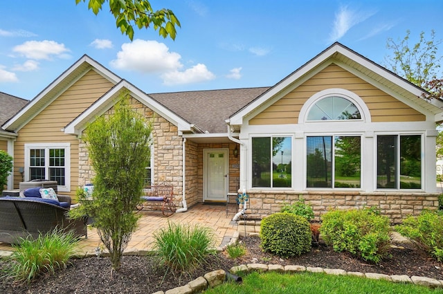 2696 Prestwick Village Cir, Springfield, OH 45503 - view of front of home featuring stone siding, roof with shingles, and a patio