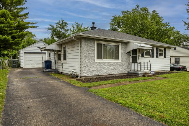 5385 Woodbine Ave, Dayton, OH 45432 - view of front of property with an outbuilding, driveway, a detached garage, a front yard, and stone siding