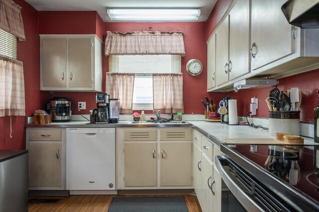 5385 Woodbine Ave, Dayton, OH 45432 - kitchen with white dishwasher, wall chimney exhaust hood, electric range, light wood-style flooring, and cream cabinetry