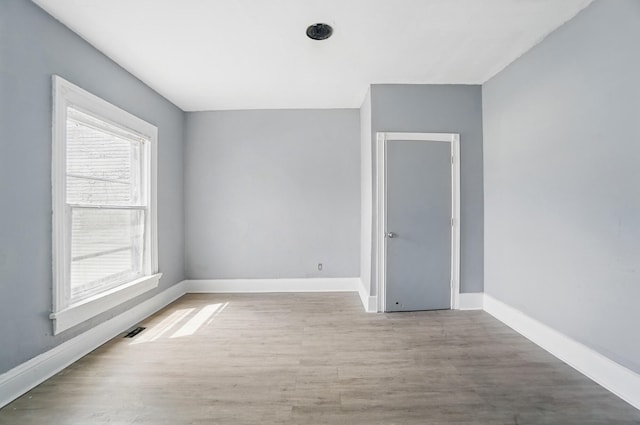 empty room with baseboards and wood finished floors