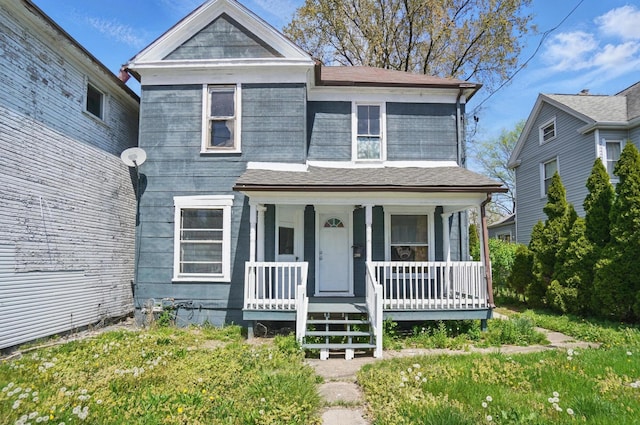 view of front of house featuring covered porch and a shingled roof
