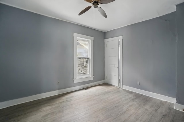 unfurnished room with wood finished floors, ceiling fan, and baseboards