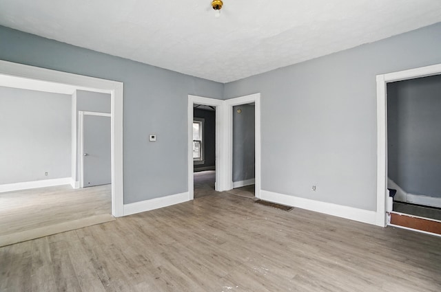 interior space featuring wood finished floors, visible vents, and baseboards