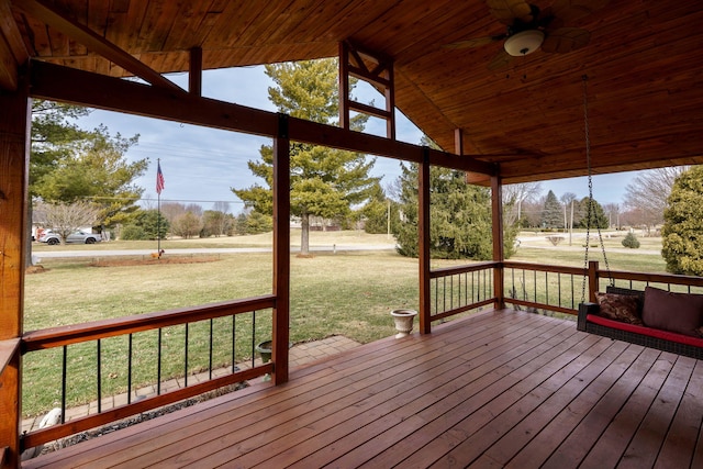 wooden terrace featuring ceiling fan and a lawn