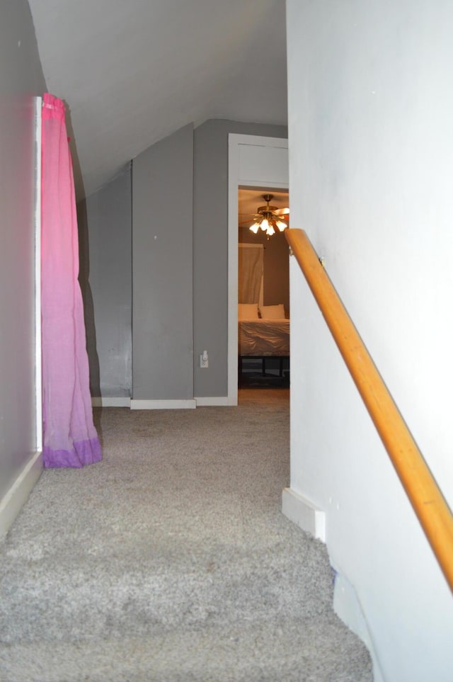 stairway featuring vaulted ceiling and carpet