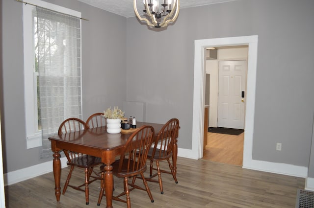 dining area with an inviting chandelier, baseboards, and wood finished floors