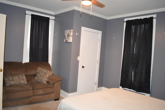 carpeted bedroom with baseboards, ornamental molding, and a ceiling fan