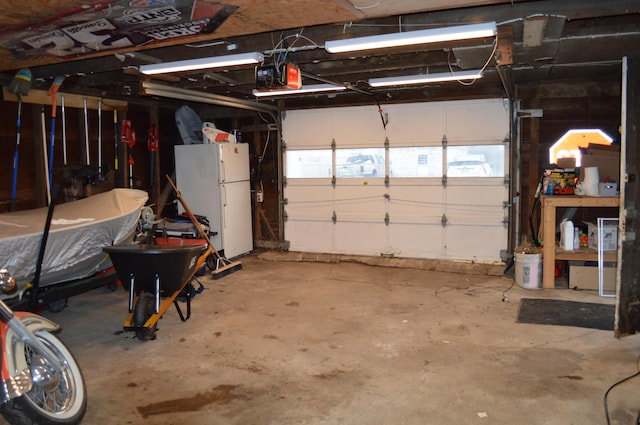 garage featuring freestanding refrigerator and a garage door opener