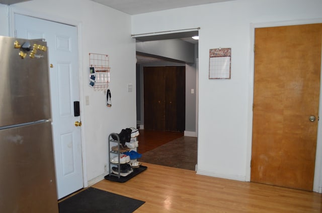 corridor with baseboards and wood finished floors