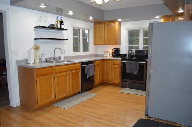 kitchen with dishwasher, electric stove, light wood-style flooring, freestanding refrigerator, and a sink