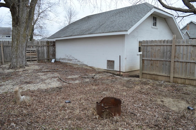 exterior space featuring a shingled roof and fence