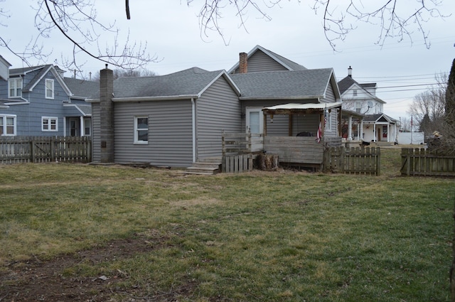 back of property featuring fence private yard, a chimney, and a lawn