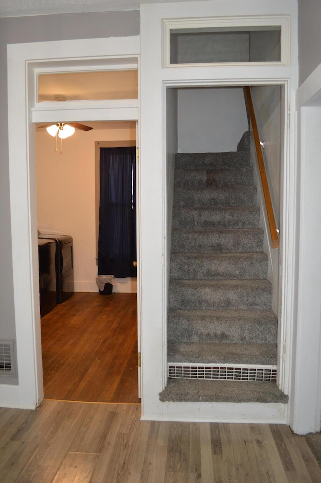 staircase featuring ceiling fan, wood finished floors, and visible vents