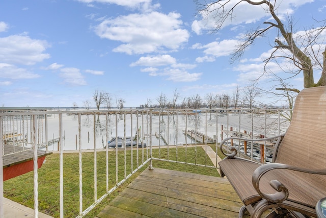 wooden terrace with a dock, a yard, boat lift, and a water view