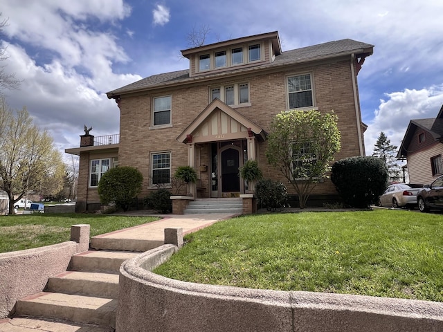 traditional style home with brick siding, a shingled roof, and a front yard