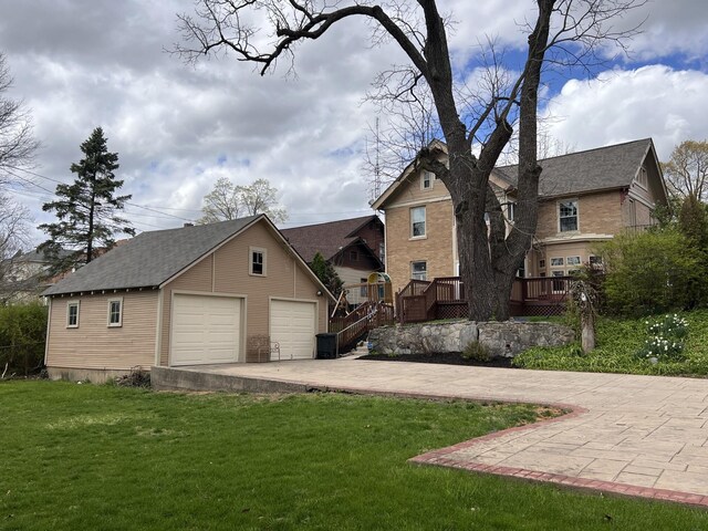 view of front of house featuring an outdoor structure, a wooden deck, a front yard, and a garage