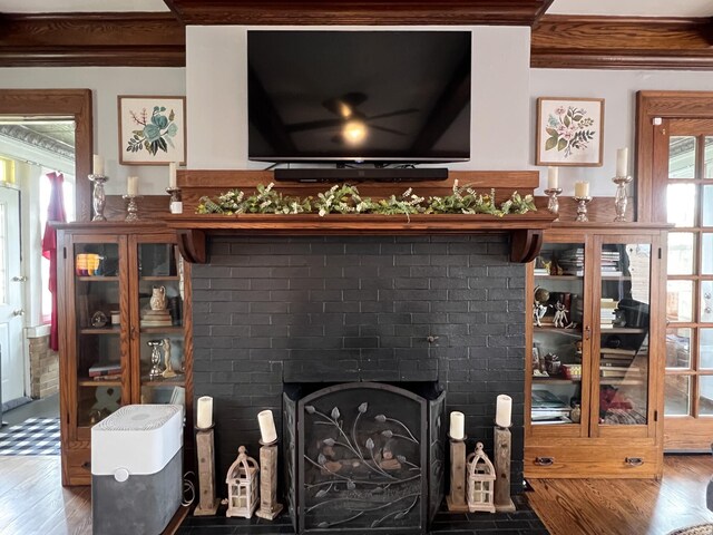 room details with crown molding, wood finished floors, and a fireplace