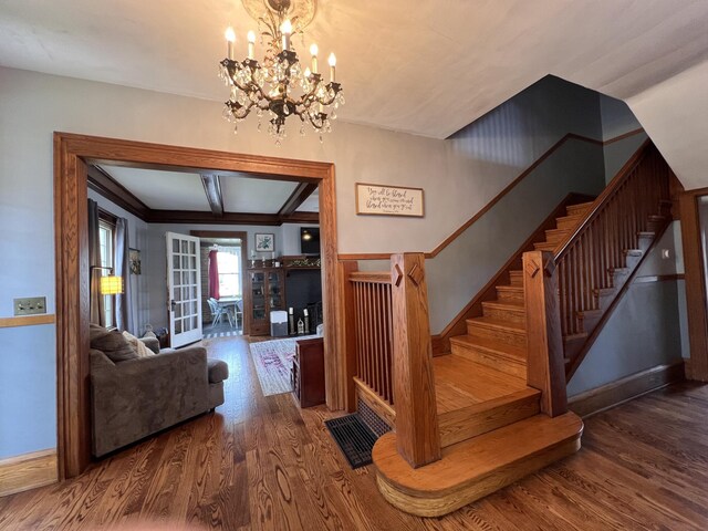 stairs with a chandelier and wood finished floors
