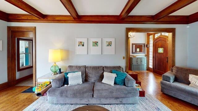 living area with beamed ceiling, baseboards, wood finished floors, and coffered ceiling