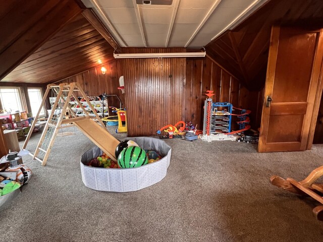 game room with wood walls, vaulted ceiling, and carpet flooring