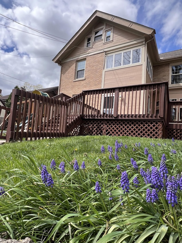 rear view of house with a wooden deck and brick siding
