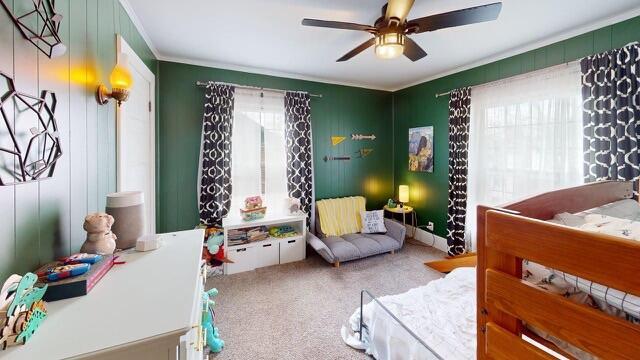 carpeted bedroom with ceiling fan and ornamental molding