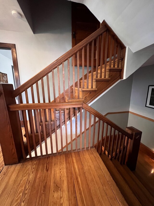 stairs featuring wood finished floors and baseboards