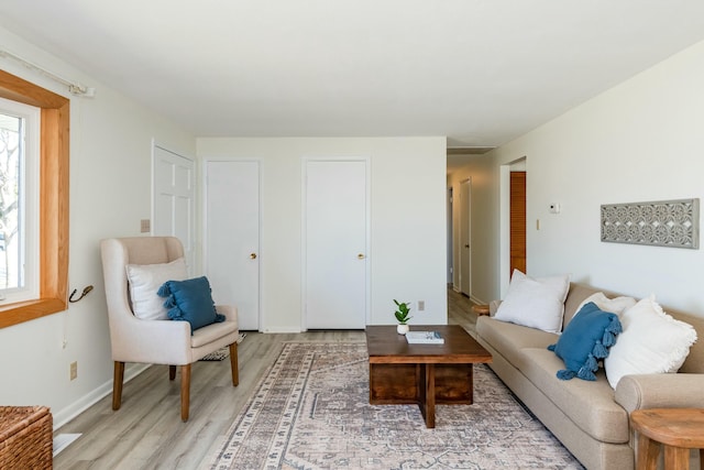 living area with baseboards and light wood finished floors