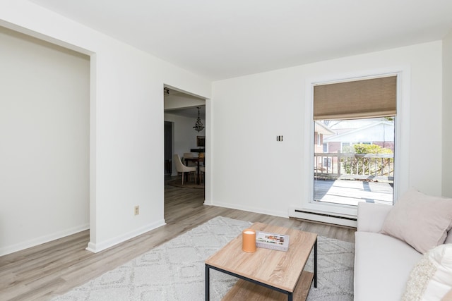 living room with baseboard heating, baseboards, and wood finished floors