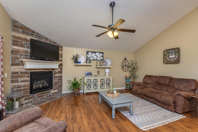 725 Loxley Ln, Troy, OH 45373 - living room featuring vaulted ceiling, wood finished floors, a ceiling fan, a textured ceiling, and a stone fireplace