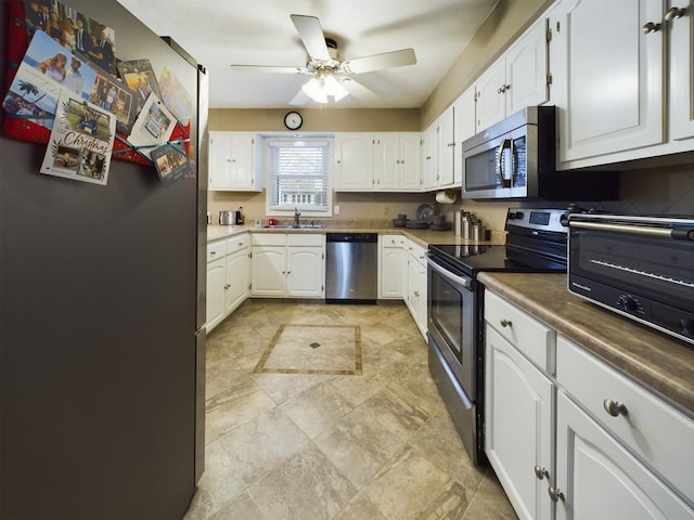 kitchen featuring ceiling fan, stainless steel appliances, and white cabinets