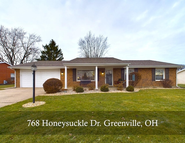 single story home with a porch, a garage, and a front yard