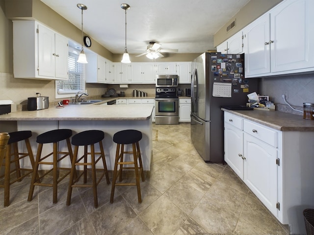 kitchen with white cabinetry, stainless steel appliances, kitchen peninsula, and sink