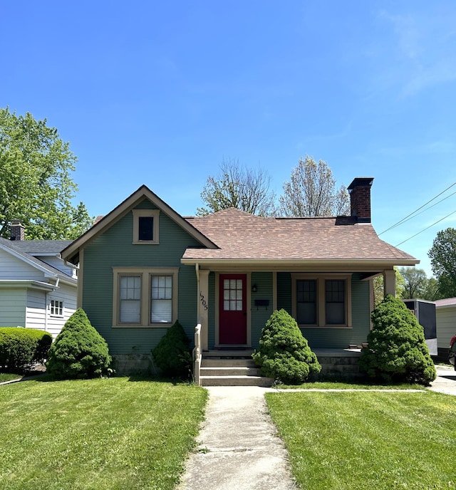 1205 S Ridge Ave, Troy, OH 45373 - bungalow-style home with a chimney, a front yard, roof with shingles, and covered porch